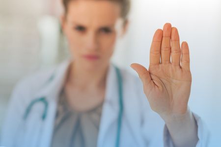 Женщина врач вытянула руку в протесте